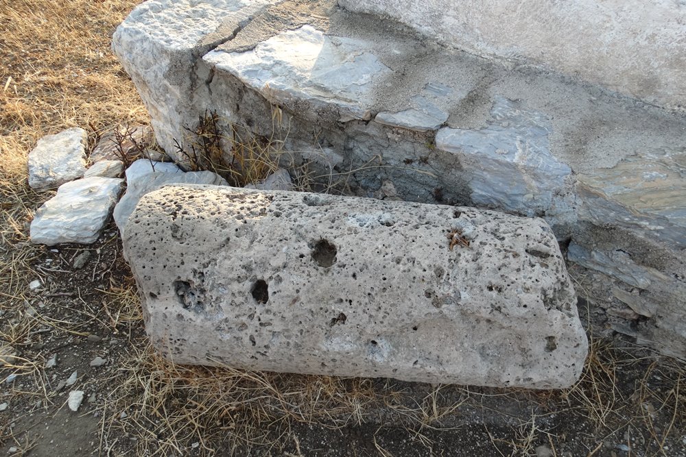 a piece of ancient column in front of the church